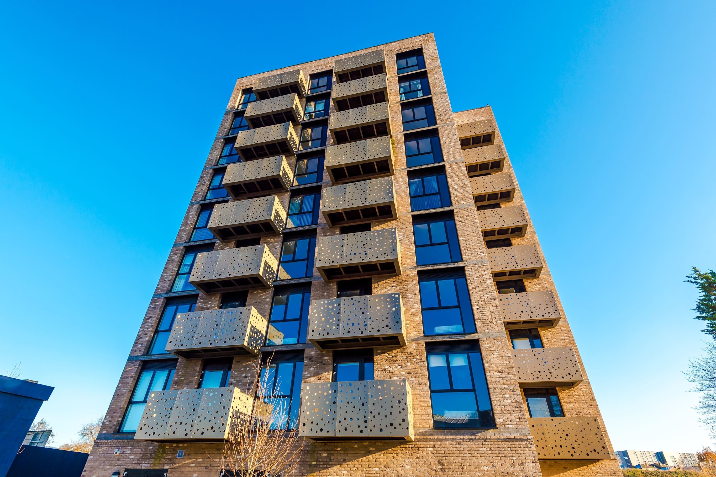 A multi-story building with balconies and large windows.