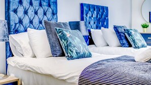 A bedroom with a large bed, multiple pillows, and a headboard with a tufted design. - NEW Pristine Apartment City Centre Amazing Views (London)
