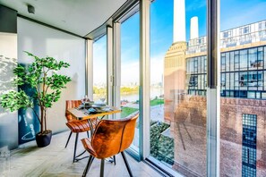 A dining area with a table, chairs, and a potted plant. - NEW Pristine Apartment City Centre Amazing Views (London)