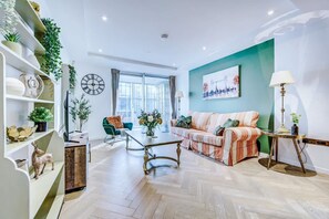 A modern living room with a sofa, coffee table, and decorative items. - NEW Pristine Apartment City Centre Amazing Views (London)