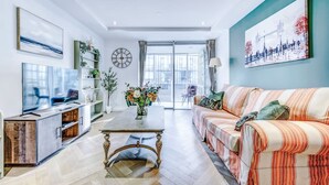A modern living room with a sofa, TV, and a dining table. - NEW Pristine Apartment City Centre Amazing Views (London)