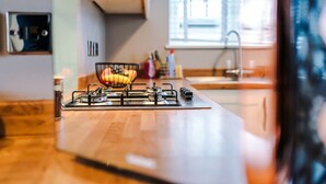 A kitchen with a gas stove, wooden countertop, and a window with blinds. - Stunning Home Amazing Location Great For Groups (Chester)