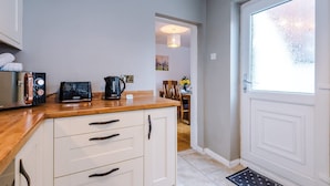 A kitchen with a wooden countertop, white cabinets, a coffee maker, and a kettle. - Stunning Home Amazing Location Great For Groups (Chester)
