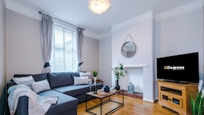 A modern living room with a sofa, coffee table, TV, and a fireplace. - Stunning Home Amazing Location Great For Groups (Chester)