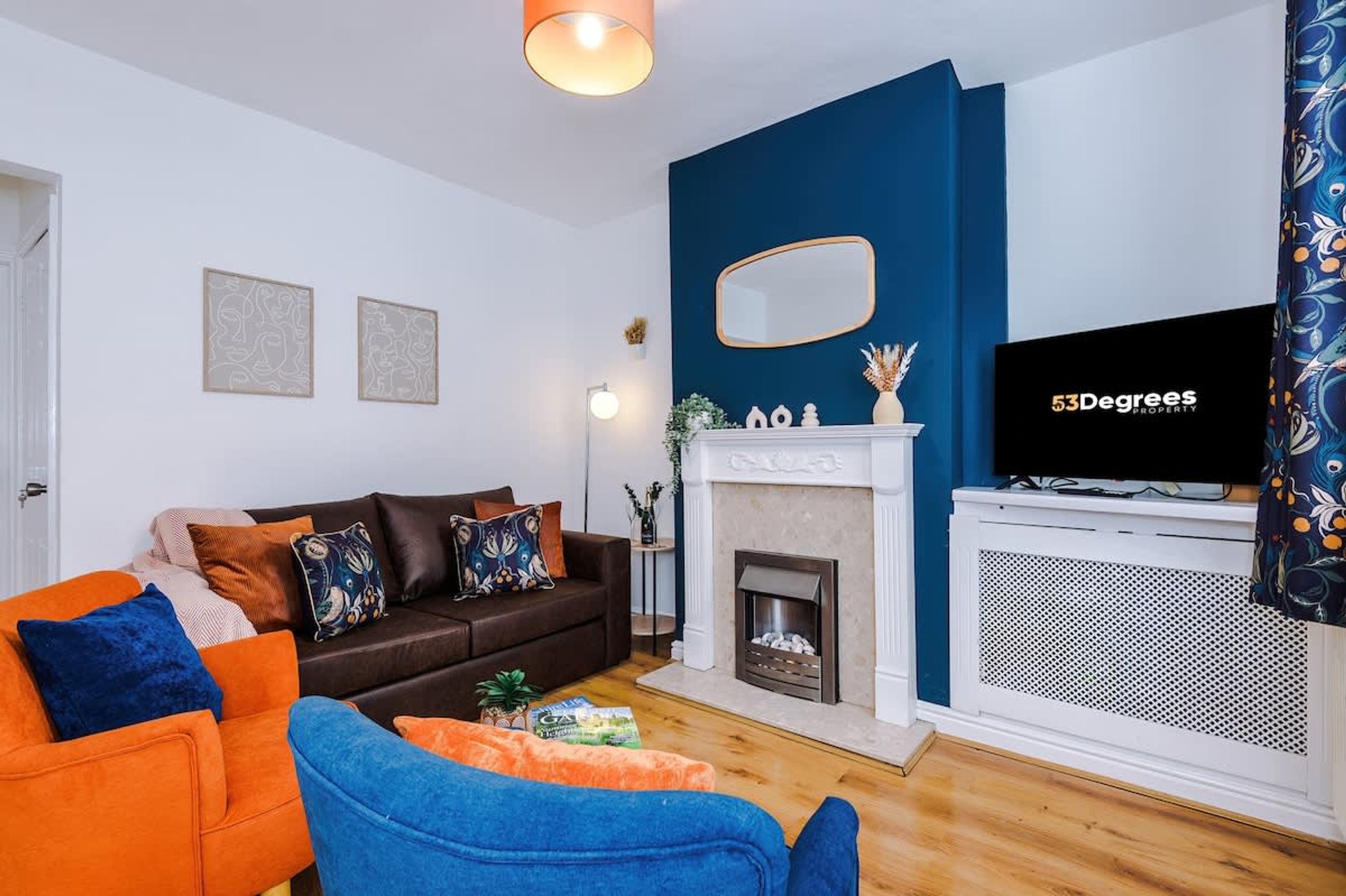 A living room with a fireplace, a television, and a sofa.