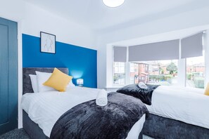 Habitación de hotel con dos camas, vista a edificios, un cuadro en la pared y una ventana con vistas.