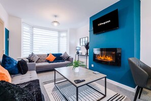 Una sala de estar moderna con sofá, mesa de centro y chimenea.
