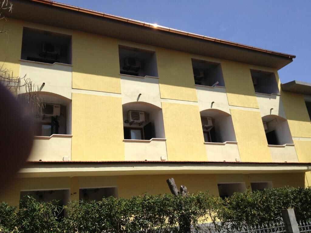 A multi-story building with balconies and air conditioning units.
