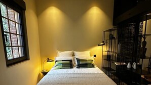 Une chambre avec un grand lit, une fenêtre donnant sur un beau paysage, un bureau et une chaise.