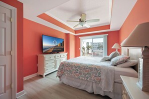 A bedroom with a bed, a ceiling fan, a TV, a dresser, and a window with a view. - Luxury 4-bedroom oceanblock retreat on 138th Street offering plenty of space and a pool (Ocean City)
