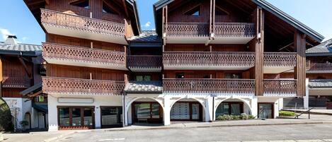 A multi-story wooden building with balconies and a covered entrance.