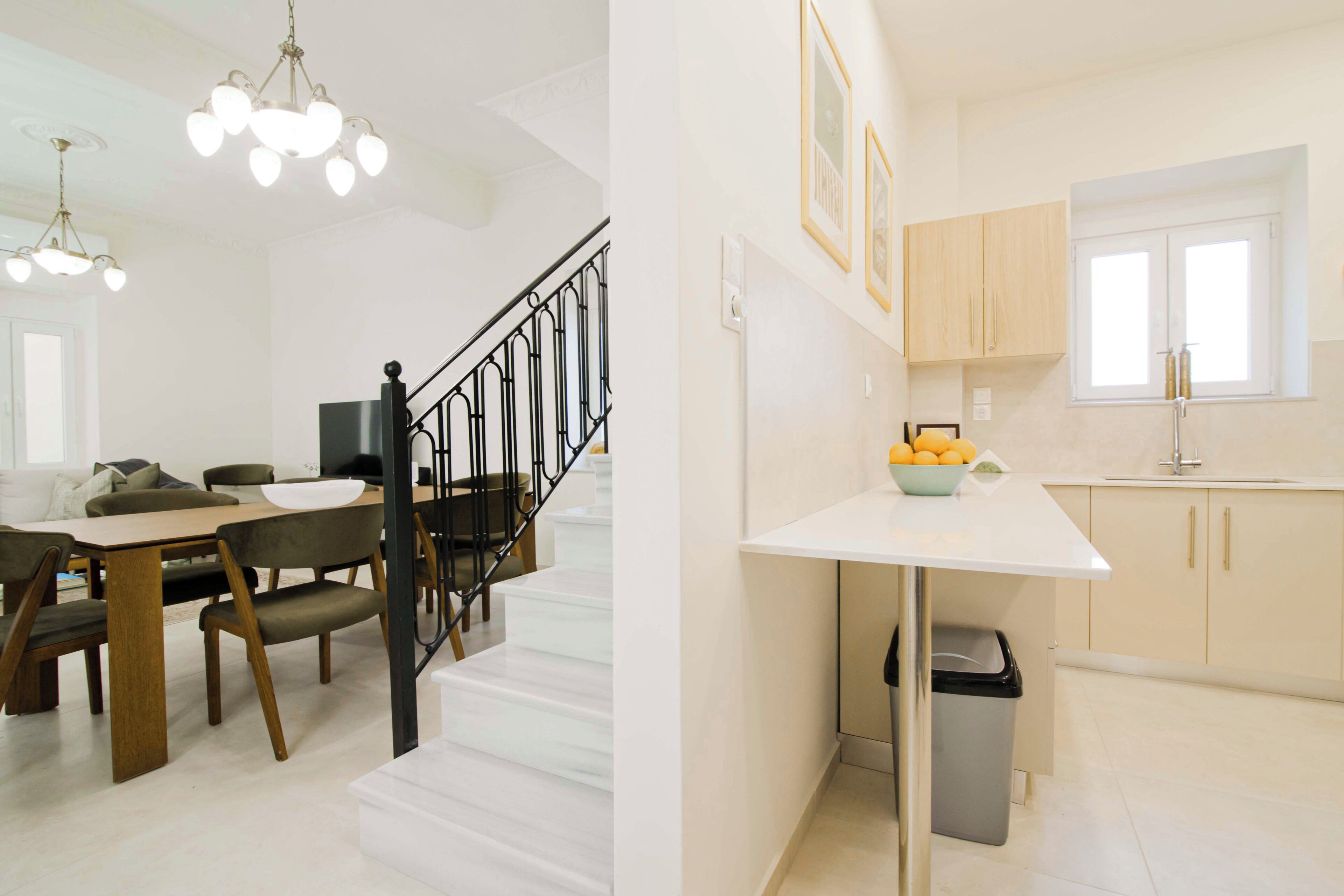 Un intérieur moderne comprenant un escalier, un coin repas et une cuisine.