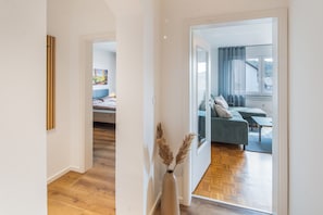 Ein modernes Interieur mit einem Flur, der in ein Schlafzimmer und ein Wohnbereich führt.