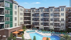 Un immeuble résidentiel à plusieurs étages doté d’une piscine et de chaises longues.