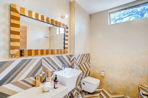 A modern bathroom with a large mirror, a sink, and a toilet. - ELIVAAS Villa 39 Serene 6BHK with Pool (Lonavala)
