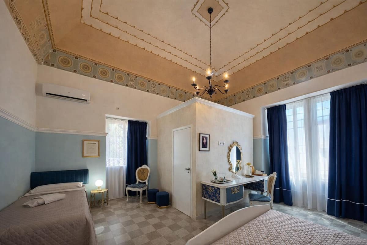 Un dormitorio con cama, escritorio, silla y candelabro.
