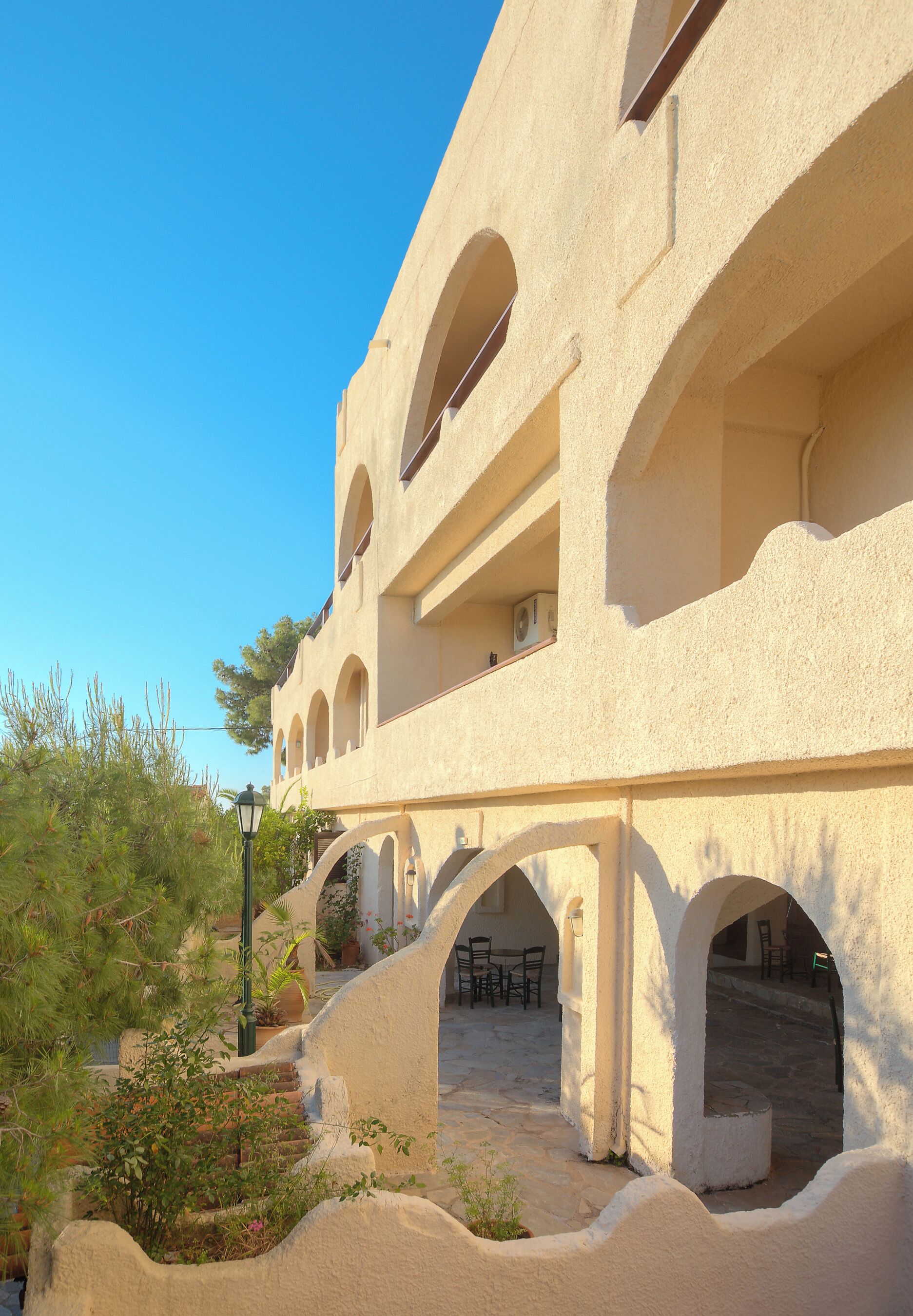 A building with multiple arches and a courtyard with outdoor seating.