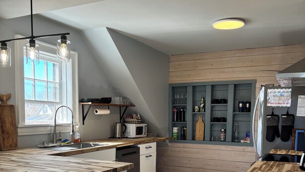 A modern kitchen with a central island, wooden countertops, and a built-in stove. - Coastal Trail Cottages - Captain Jack's Lookout (Morell)