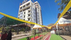 Un hotel con diversi piani, posti a sedere all'aperto e una vista panoramica sul paesaggio circostante.