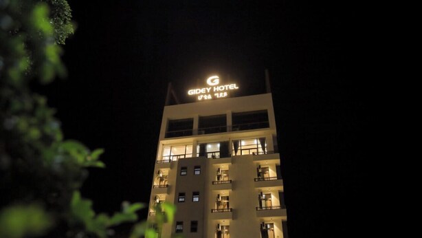 Un edificio a più piani con un cartello che riporta 'Gidey Hotel' in cima.