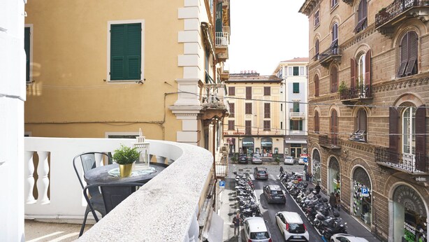 A narrow street with parked cars and motorcycles, buildings with balconies, and a visible hotel sign. - Hotiday La Spezia Quiet Night (La Spezia)