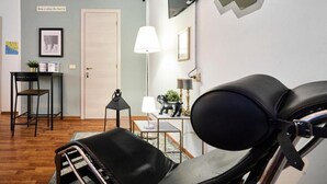 A room with a bed, a desk, a chair, a lamp, and a television mounted on the wall. - Hotiday La Spezia Quiet Night (La Spezia)