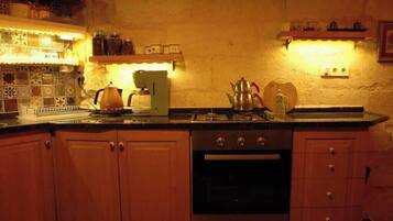 Eine Küche mit Holzausstattung, einem Herd und einer Kaffeemaschine.