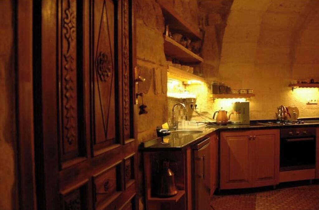 Una cocina con gabinetes de madera, un lavamanos y una estufa.