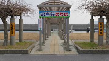 A covered walkway leading to a waterfront area with a sign indicating a parking stop.