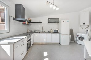 A modern kitchen with white cabinets, stainless steel appliances, and a built-in microwave. - Family Retreat 5 Minutes’ Walk from D. Luís I Bridge (Vila Nova de Gaia)