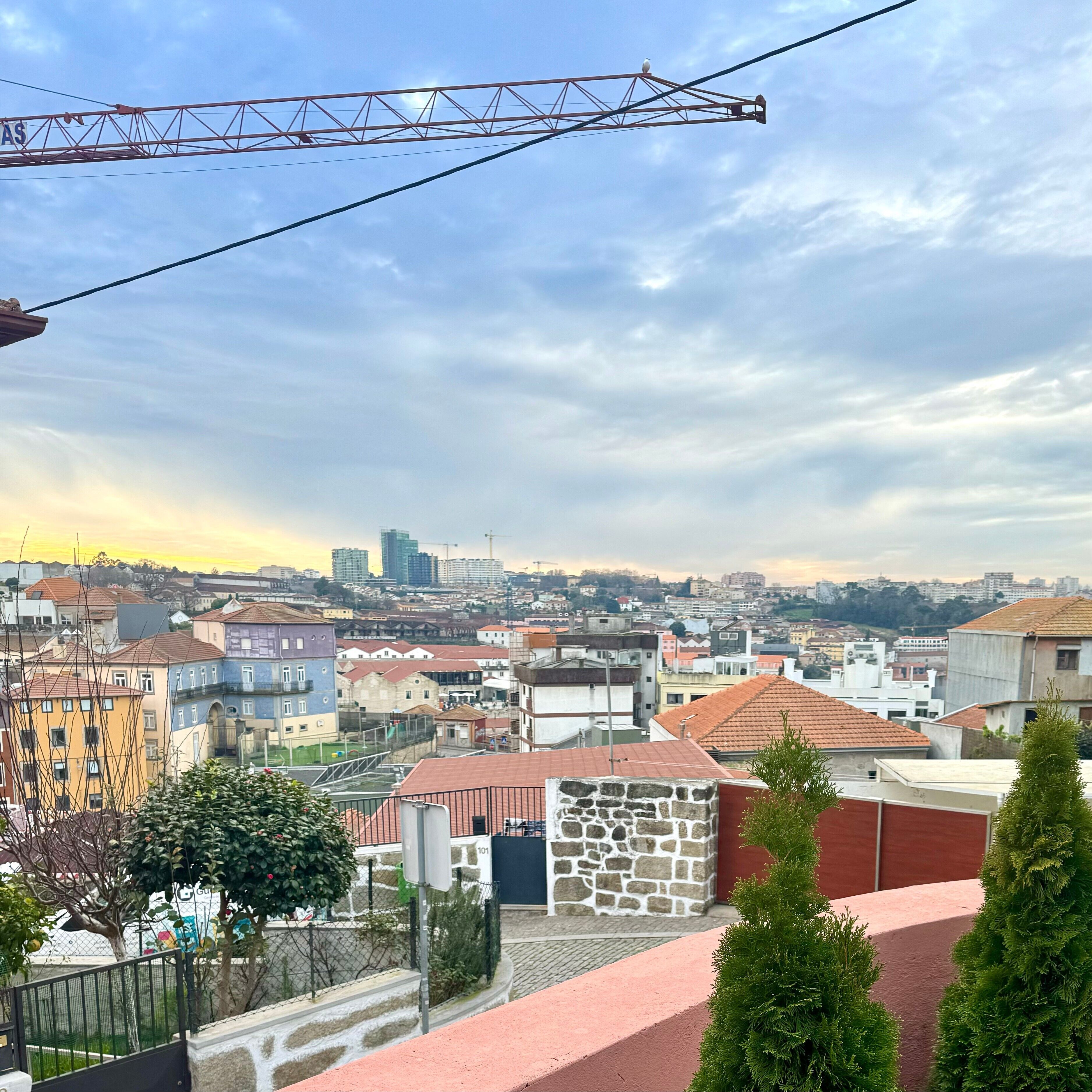 Paisaje urbano con edificios, una grúa y cielo despejado.