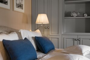 A neatly made bed with blue and white pillows, a bedside lamp, and a shelf with a toy car. - Tremendous 4-bedroom villa Celeste by Casa del Sole with pool in Vabriga (Vabriga)