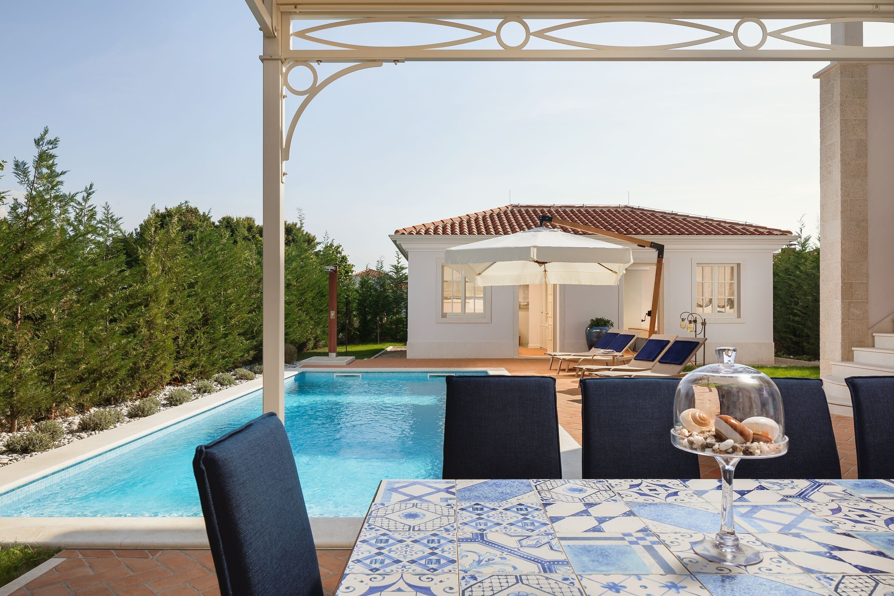 Ein Poolbereich mit Tisch, Stühlen und einer Glaskuppel.