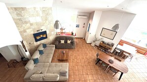 A spacious living area with a large sofa, a dining table, and a kitchen area. - Luxury villa facing the Etang salé les bains beach (L'Étang-Salé)