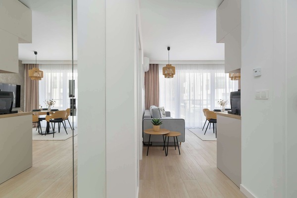 A view through a doorway or mirror reflecting the corridor and the entrance to the main living space.