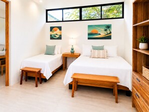 A hotel room with two beds, a wooden bench, a nightstand with a lamp, and artwork on the wall. - A Private Sanctuary in Playa Avellanas (Guanacaste Province)