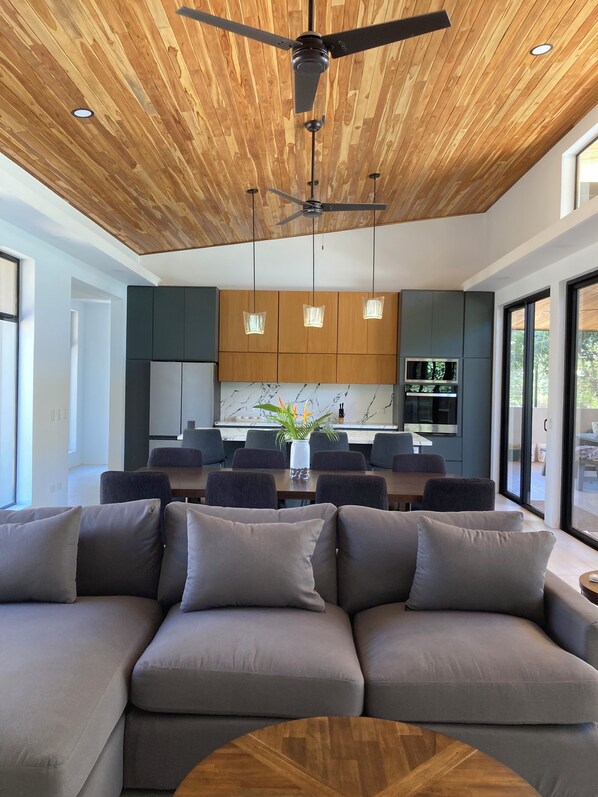 A modern kitchen with wooden ceiling, built-in appliances, and pendant lighting. - A Private Sanctuary in Playa Avellanas (Guanacaste Province)