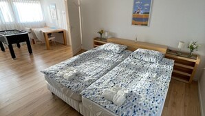 Una habitación amplia con una cama grande, una mesa de madera y un escritorio.