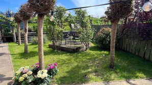 Un jardín con patio, cerca de madera y cielo despejado.