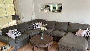 Una sala moderna con un sofá seccional, una mesa de centro y una mesita auxiliar.