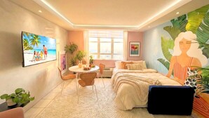 Ein Schlafzimmer mit Bett, Schreibtisch, Stuhl, Fenster und einem Bild an der Wand.