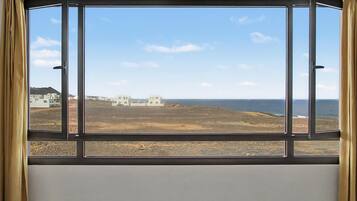 Een uitzicht op een kustlandschap, gebouwen en een heldere lucht.