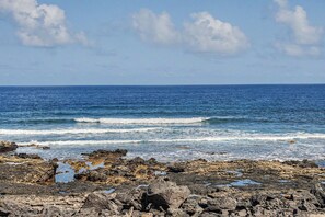 A rocky coastline with waves crashing onto the shore.