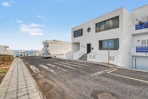 Un edificio moderno con fachada plana, grandes ventanales y una señal de paso de peatones.