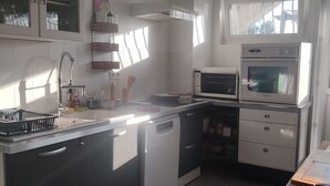 A compact kitchen with a dishwasher, a microwave, and a built-in oven. - Unique bed-and-breakfast, charming vacation rental, countryside, beach 15 minutes away (Saint-Malo-de-Guersac)