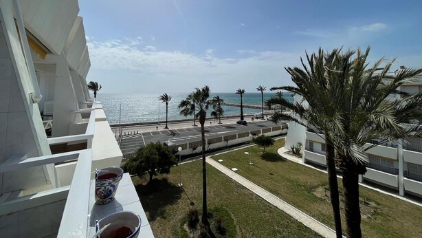 A balcony with a clear view of the sea, a parking area, and palm trees. - Terrasol Isis D Plex A 1 Minuto DE LA Playa (Velez-Malaga)