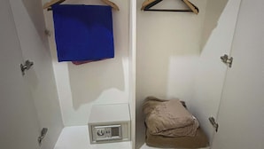 A wardrobe with two compartments, each with a hanger and a shelf. - Cozy 1-bedroom condo in perfect Manila with AC pool and fitness (Manila)