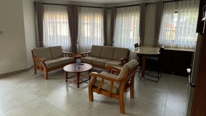Una sala de estar con un sofá modular, una mesa de centro y una mesa de comedor.