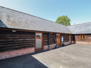 Ein Gebäude mit geneigtem Dach, Holzfassade und einer großen Glasdoor.