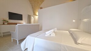 Ein Hotelzimmer mit einem Bett, einem Schreibtisch, einem Stuhl und einem an der Wand montierten Flachbildfernseher.